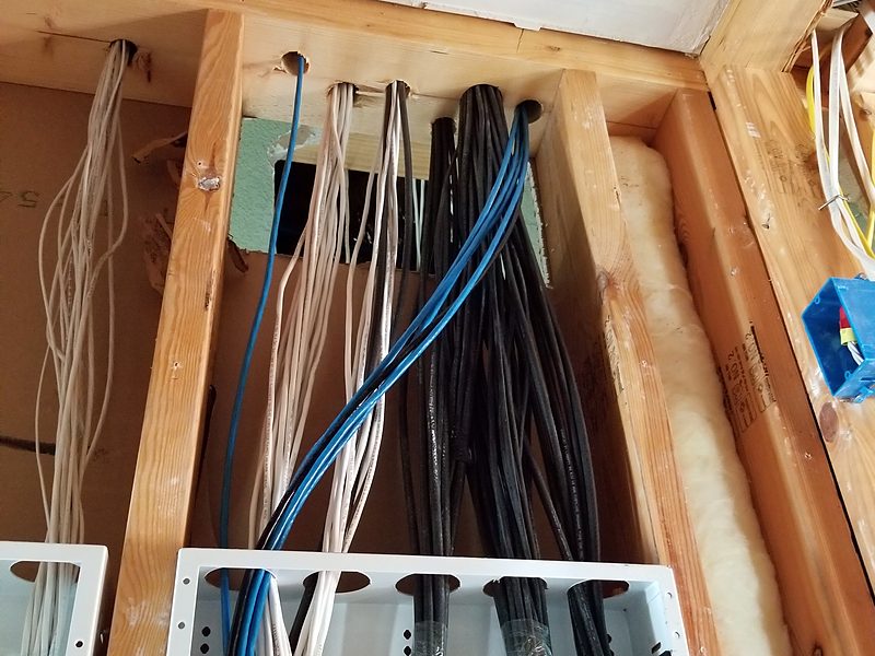 Dozens of cable runs dropping through the top plate into wall enclosures