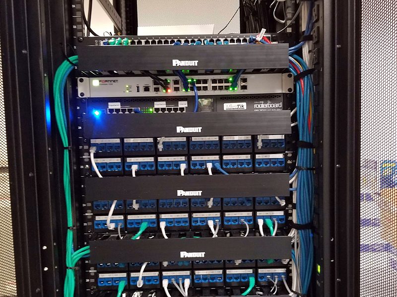 Rack of patch panels with dressed blue and green patch cords